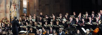Chorsänger stehen im Altarraum und singen