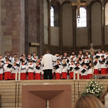 Kinder singen in Chorkleidung im Altarraum