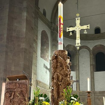 große Osterkerze mit Blumenkranz geschmückt